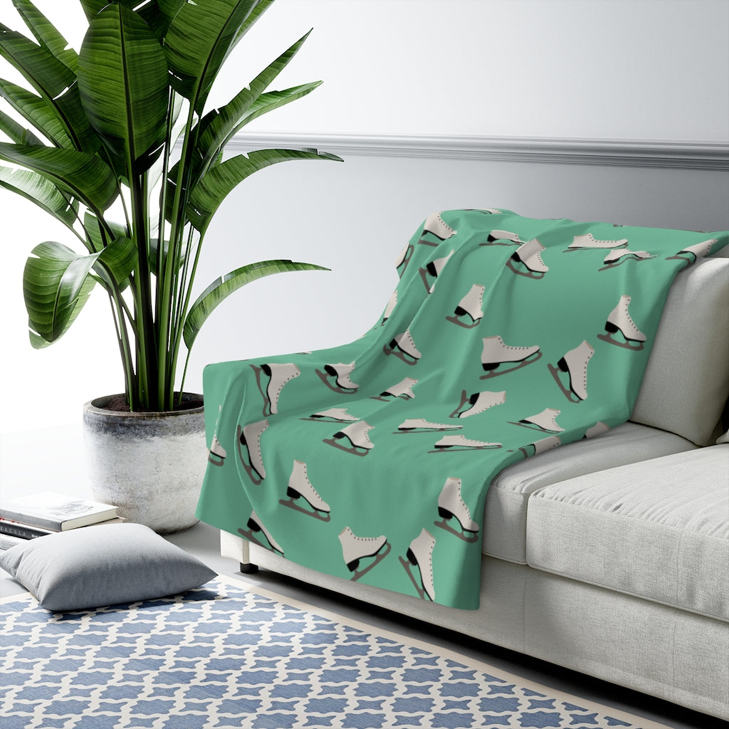 Figure Skating blanket in green sherpa material with white figure skate pattern