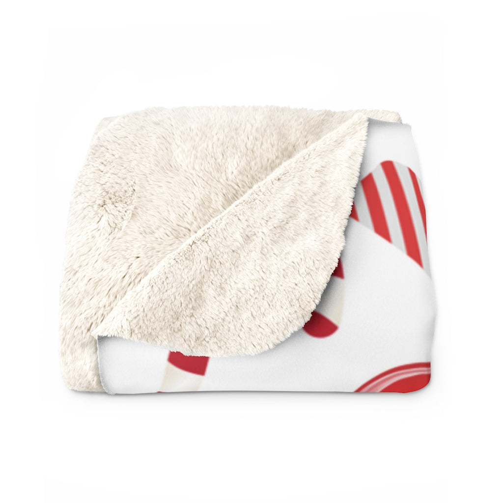 folded view of christmas sherpa blanket with candy canes and candy