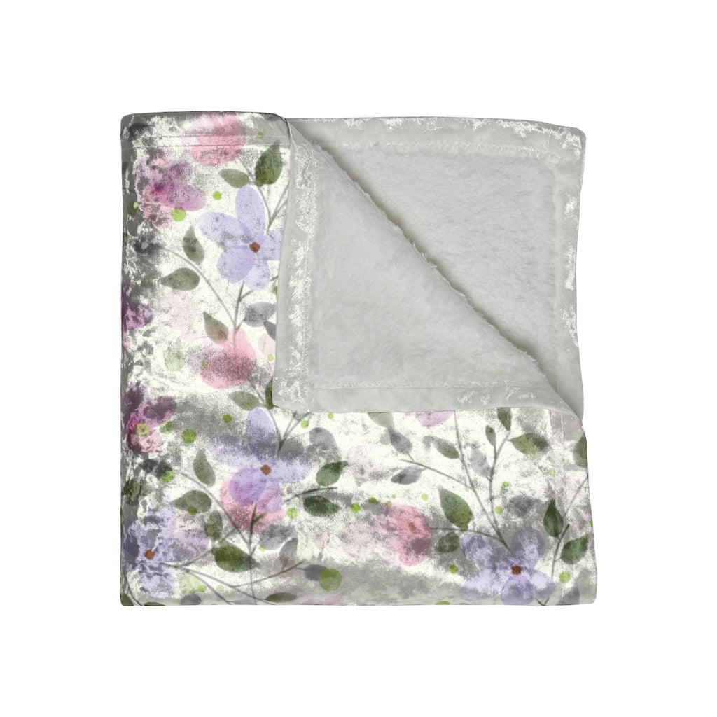 folded view of crushed velvet blanket with pink and purple pastel flower pattern.