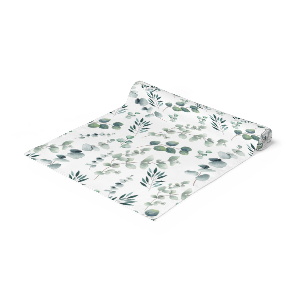 botanical table runner with green eucalyptus leaves on a white background 