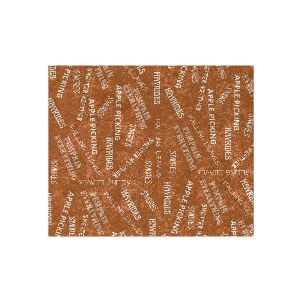 fall blanket in orange color with white written fall words 