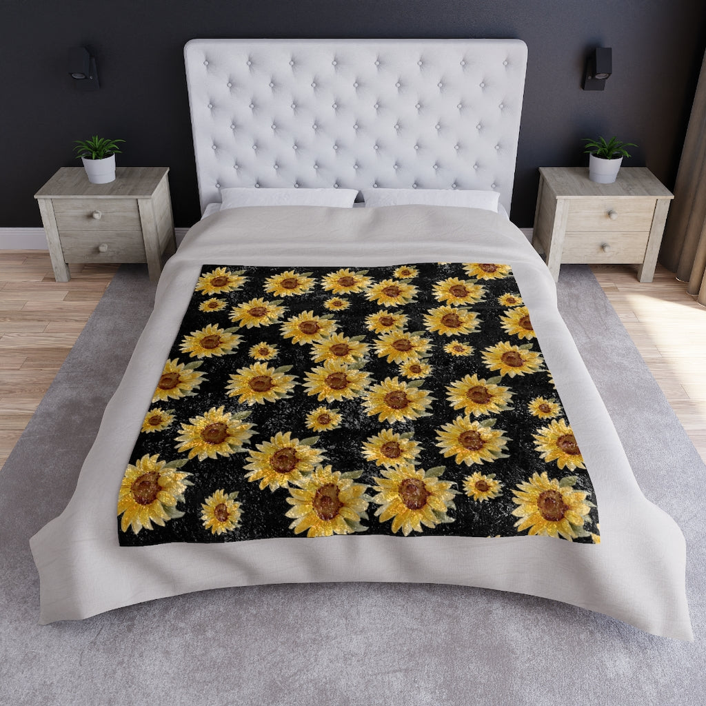 black blanket with yellow sunflowers displayed on a bed