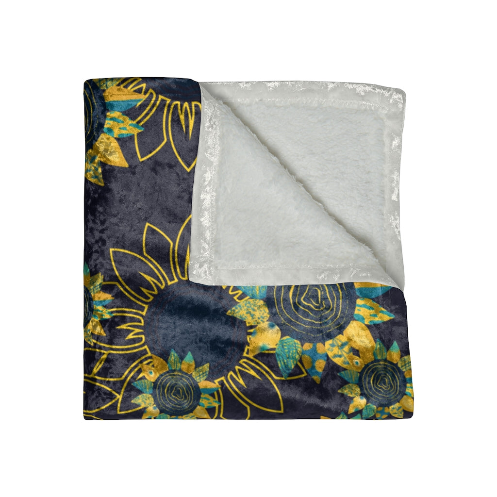 close up folded view of a navy blue sunflower blanket in crushed velvet material