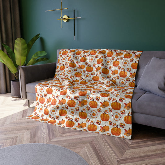orange pumpkin blanket with pumpkins and fall leaves pattern on white background