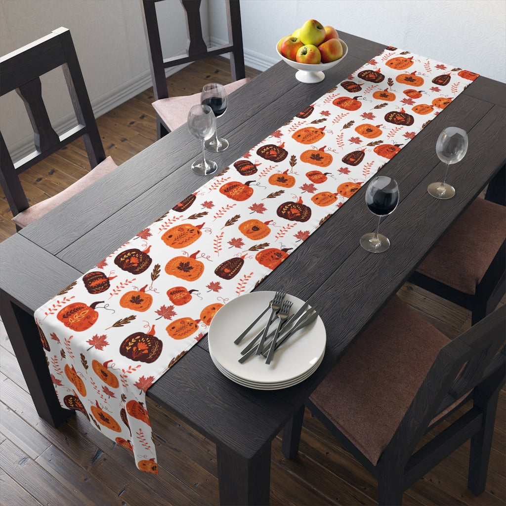 orange fall table runner with pumpkin pattern and fall leaves