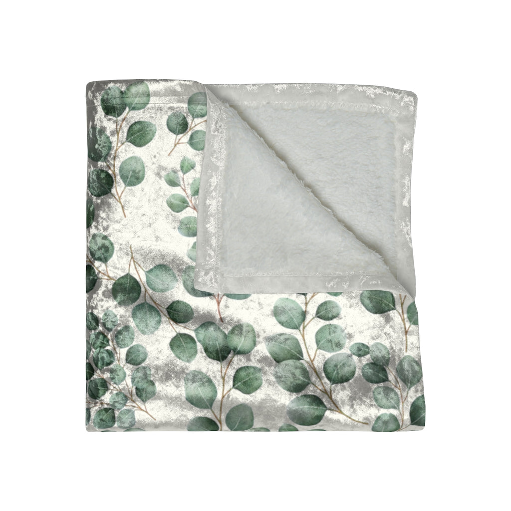 folded view of a crushed velvet blanket with green eucalyptus leaves pattern