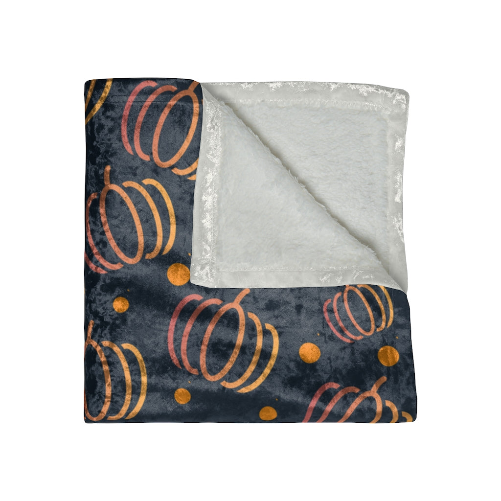 folded view of blue fall blanket with orange pumpkins and polkadots