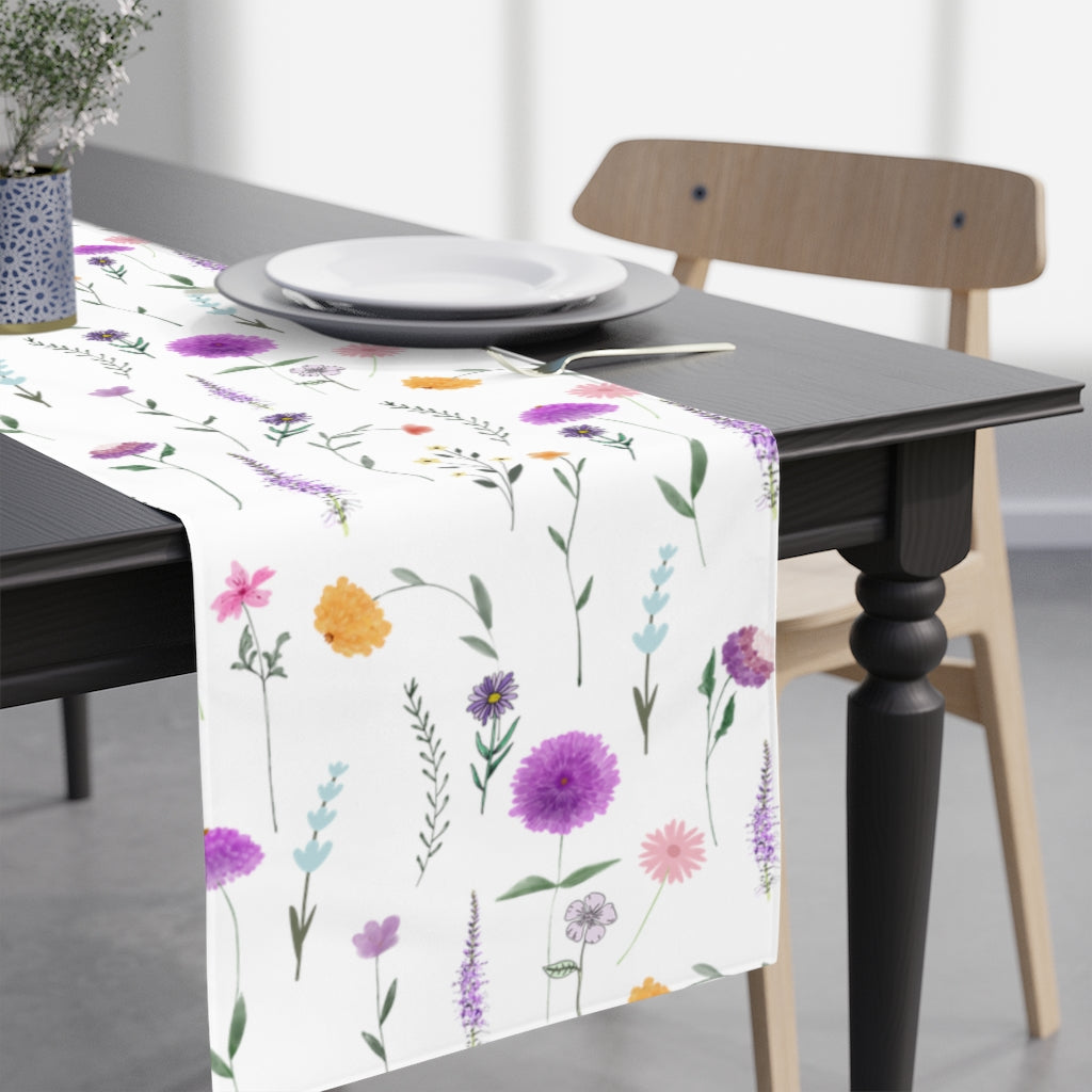 wildflower table runner with white background and purple, pink and yellow flowers and leaves