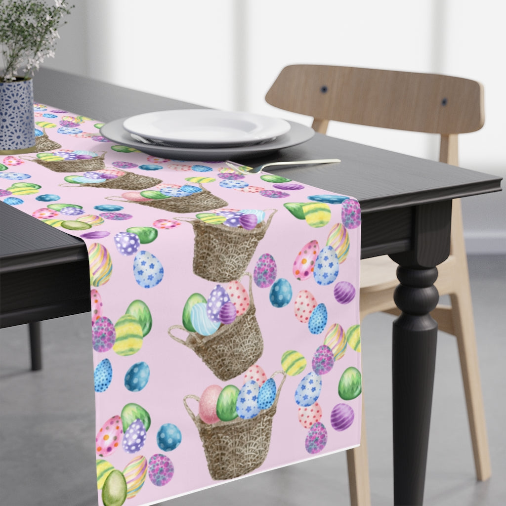 easter table runner in light pink color with stacked easter baskets and rainbow easter eggs 