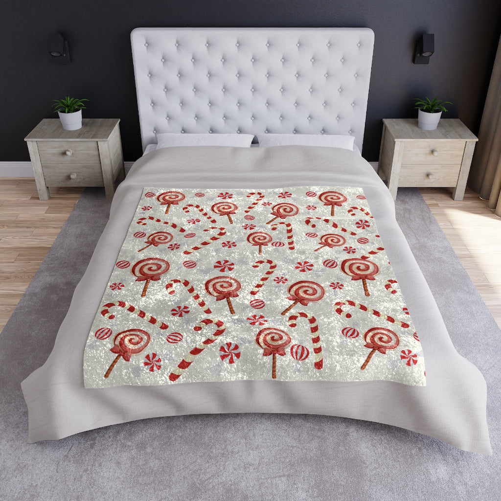 christmas blanket displayed on a bed with candy cane pattern.