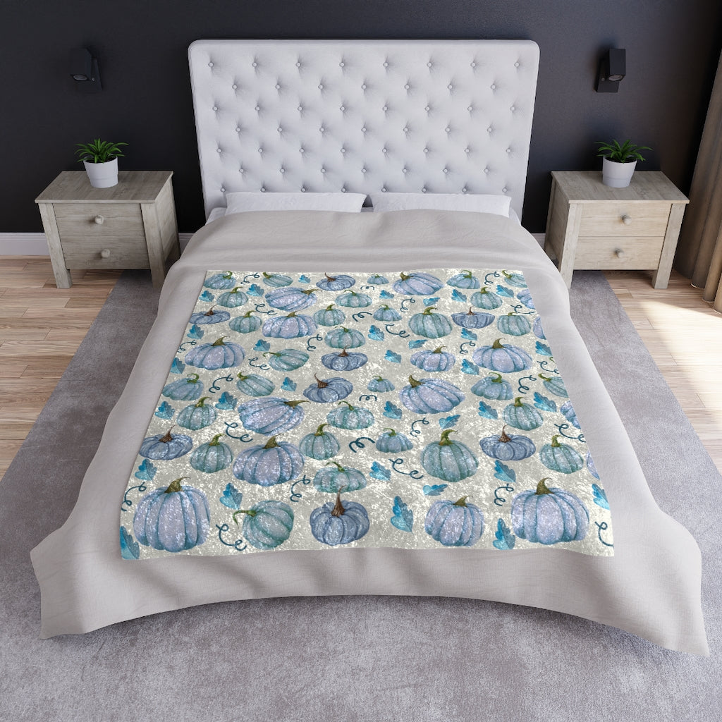 blue pumpkin fall blanket displayed on a bed