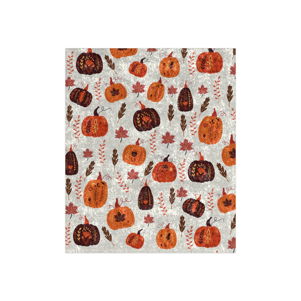 orange and brown fall blanket with pumpkin pattern and leaves