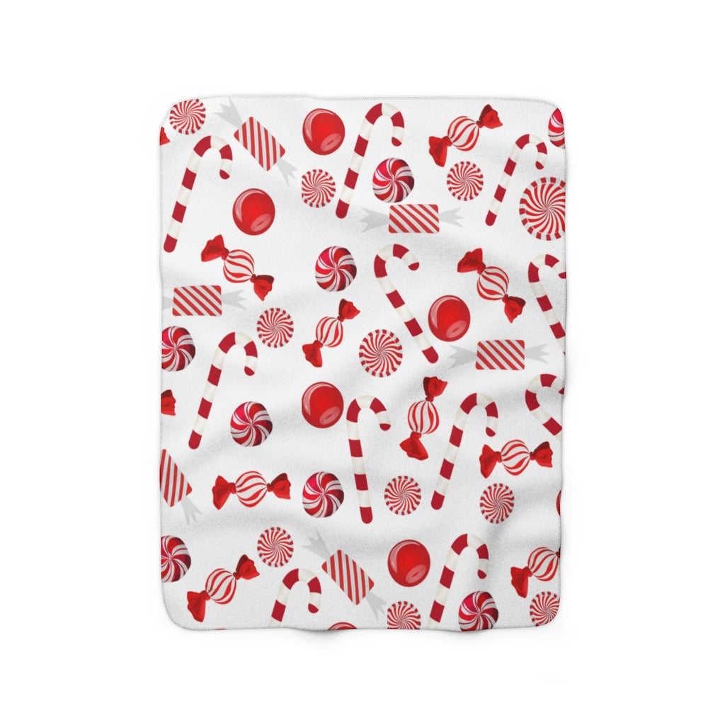 red and white christmas blanket with candy cane and christmas candy pattern